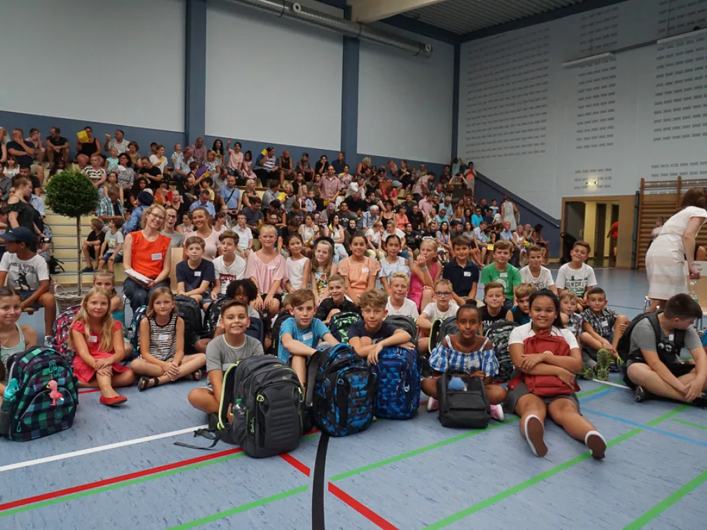 Volle Sporthalle mit Kindern und Familien.